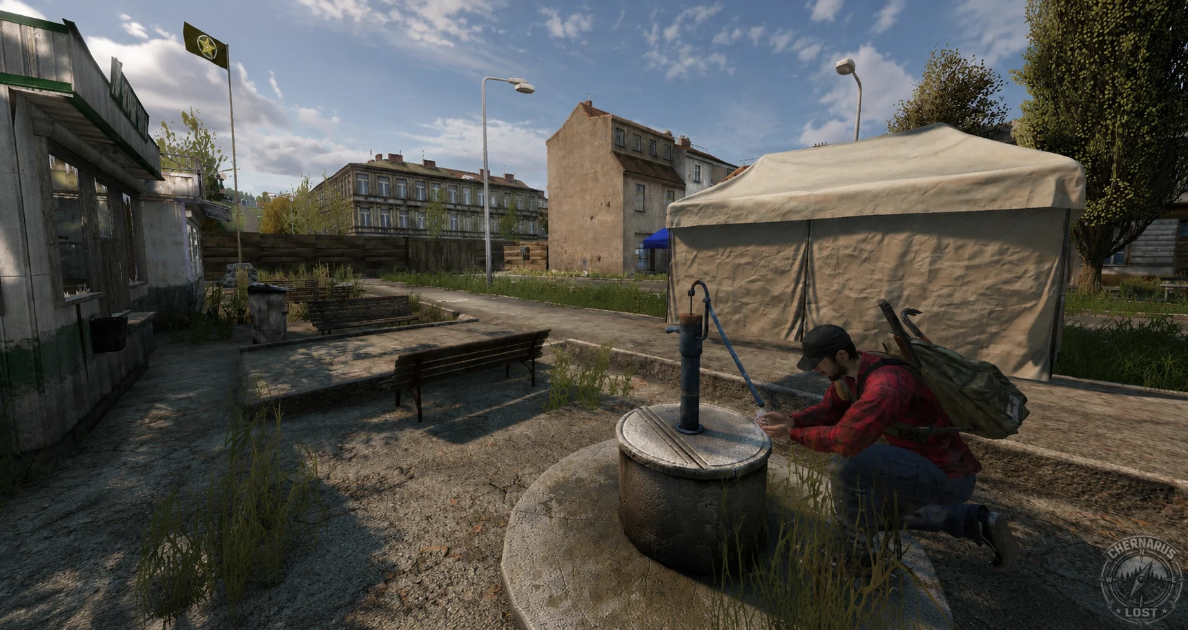 A survivor drinking at a village well beside a canvas market stall.